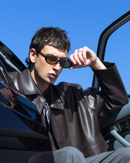 Man getting into a car with a clear blue sky background