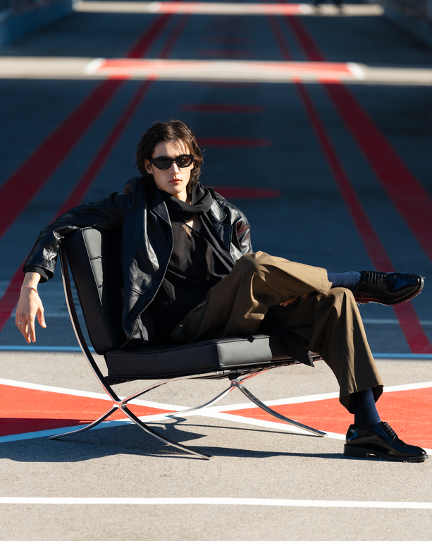 Person sitting on a chair in an urban setting with red and blue markings